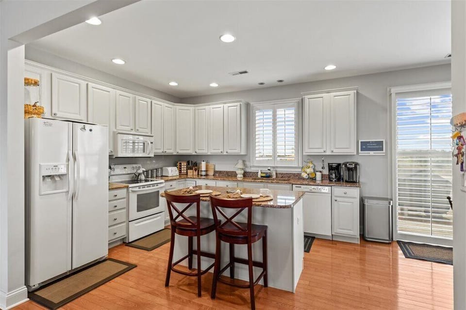 Third floor:  Kitchen with eat-in island.  Sliding glass doors to front deck.  