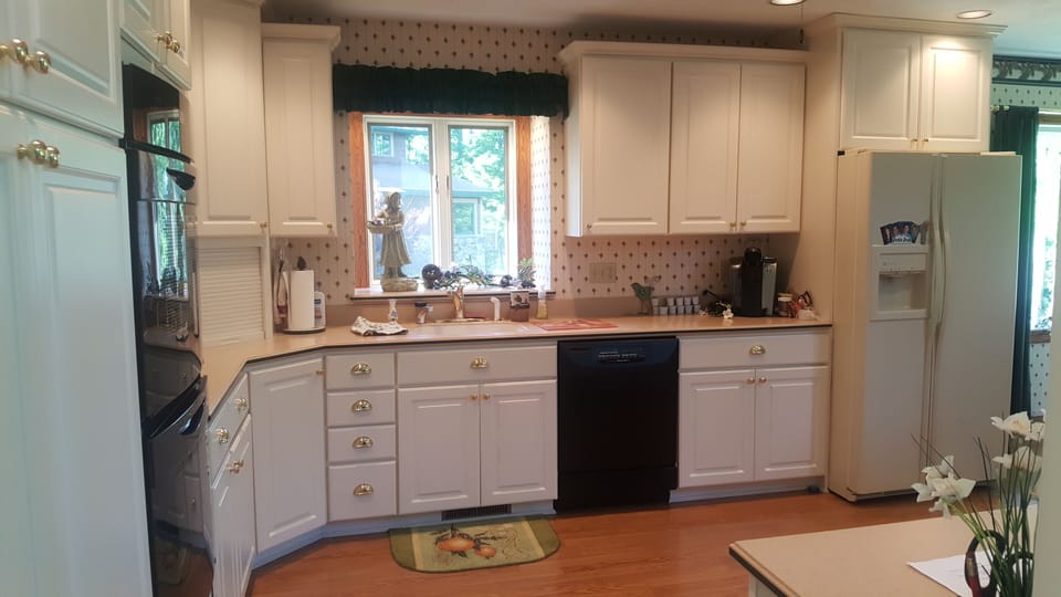 Kitchen with cooktop, double oven, dishwasher and side by side refrigerator.
