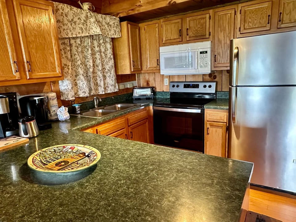 Cook with ease in a fully stocked kitchen featuring modern appliances and cabin-style charm.
