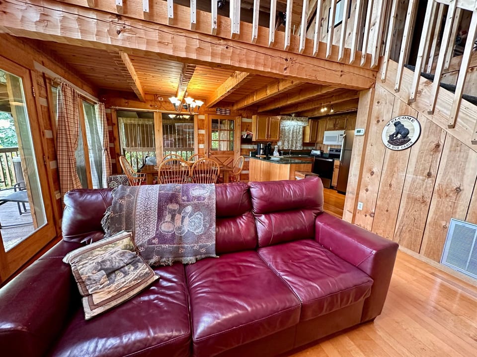 A warm, wood-paneled living space with a comfy red couch: ideal for lounging after a day outdoors.