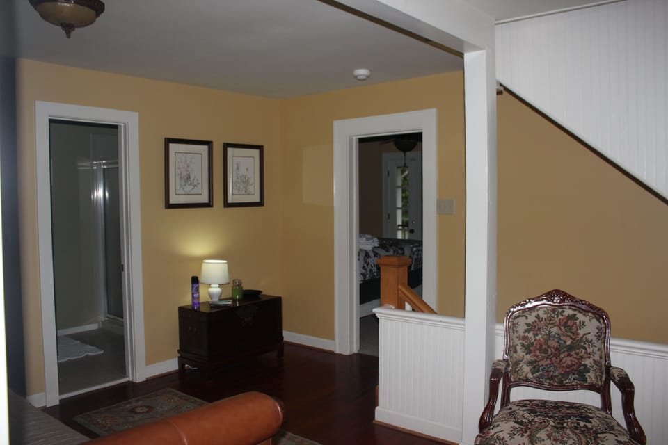 Foyer at top of stairs opens to guest bathroom  and black and white room.