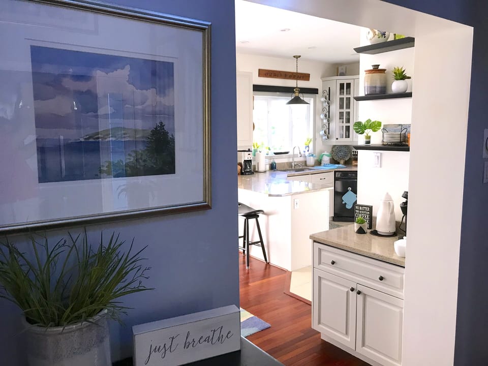 Original water color by local artist frames view to coffee center and kitchen.