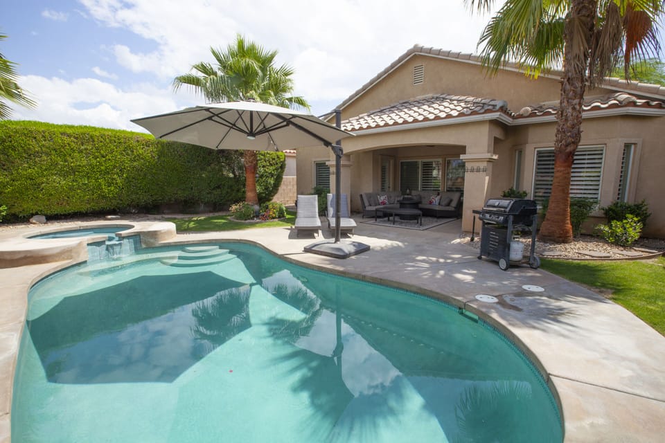Private Pool in Backyard with high hedges, and umbrellas