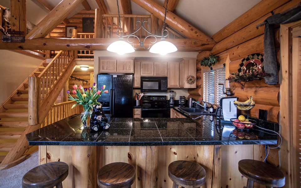 Kitchen with loft bedroom above.  Log staircase to loft.