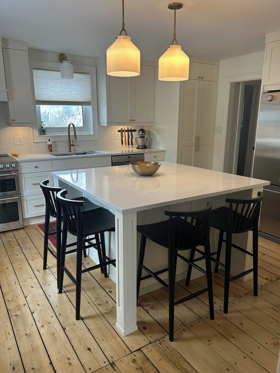 Custom kitchen with high-end appliances and vintage, pine floors. 