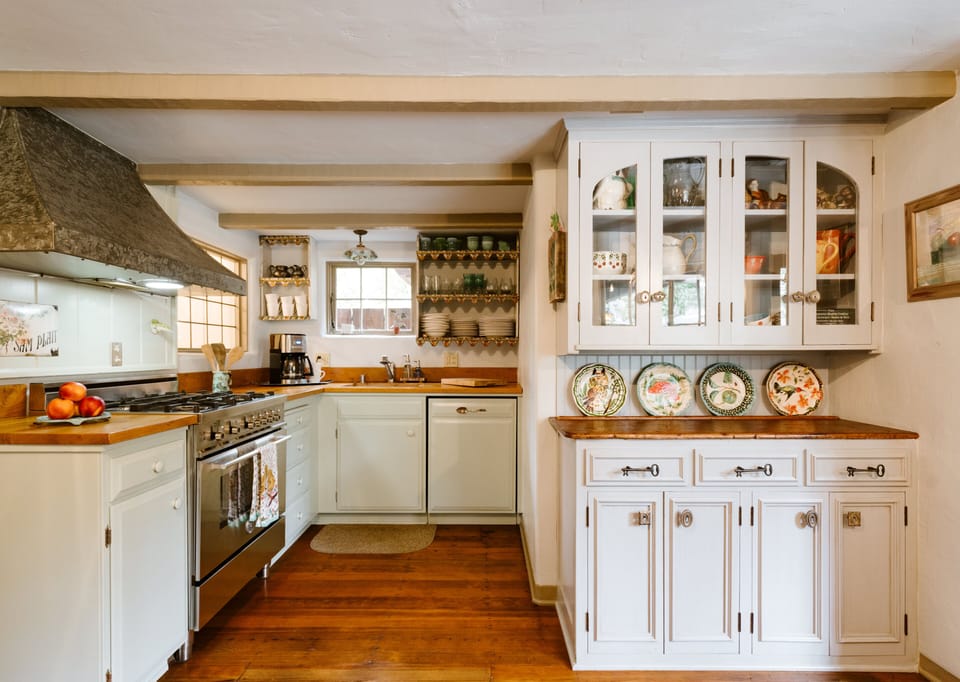 Darling kitchen with original cabinets, flooring and ceiling beams.