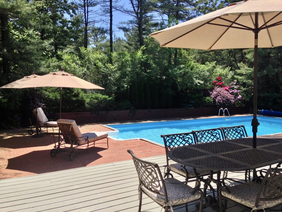 private backyard with 6 lounge chairs, dining table seating 8, bbq grill