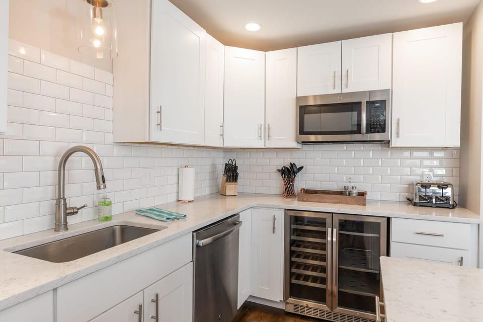 Custom wine and beer refrigerator. Commercial microwave above. Island storage.