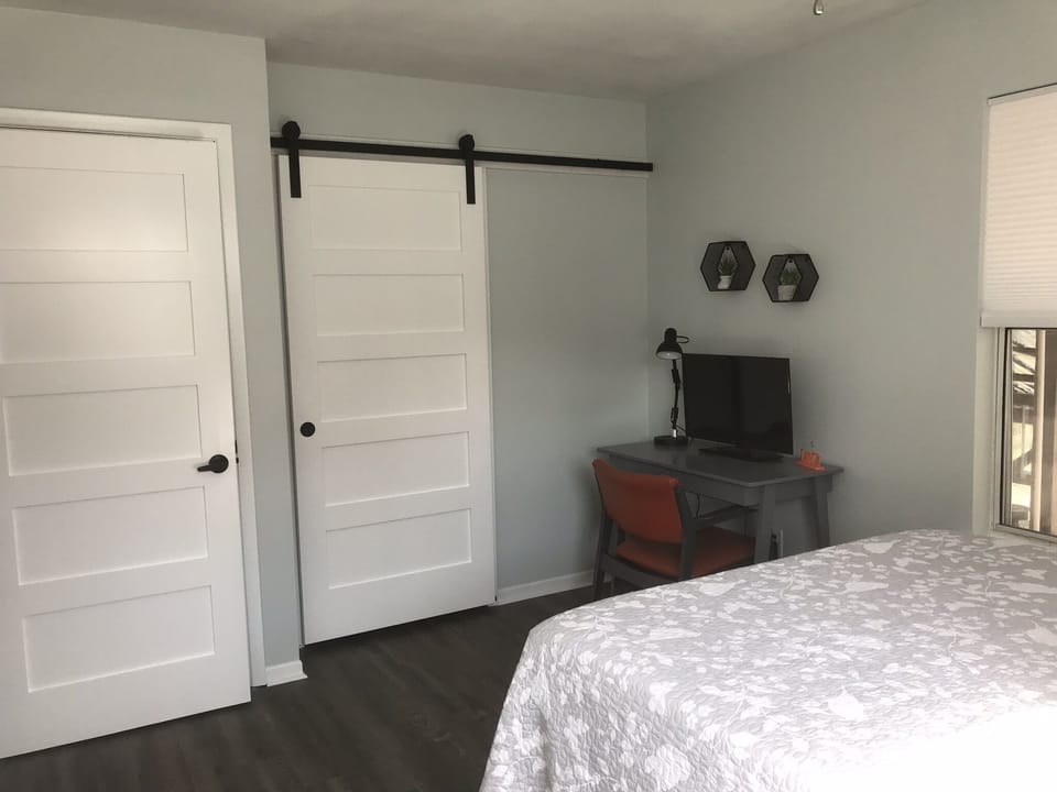 Downstairs bdrm - queen bed w/ backyard and greenhouse views. Off kitchen & bath
