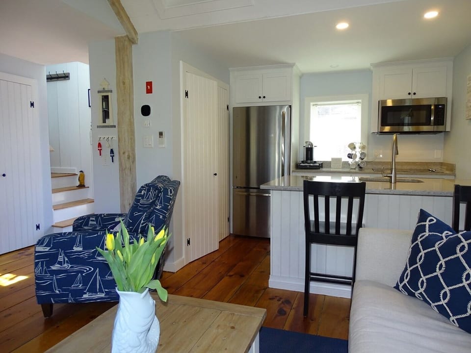 Living area opens to kitchen, showing stairs to twin bedroom