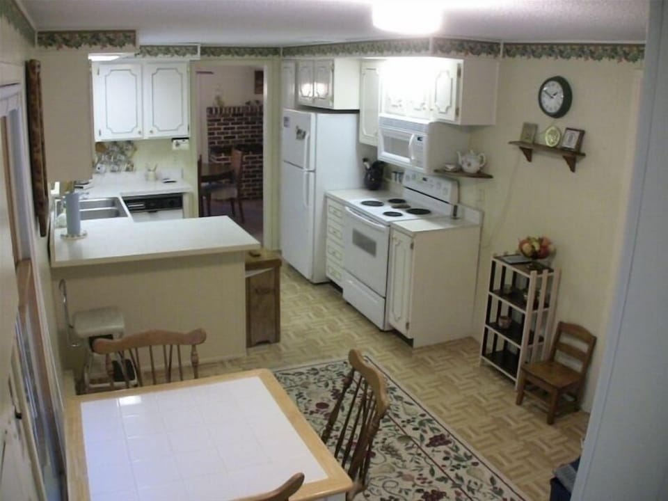 breakfast nook in the foreground, galley kitchen and dining room in the distance