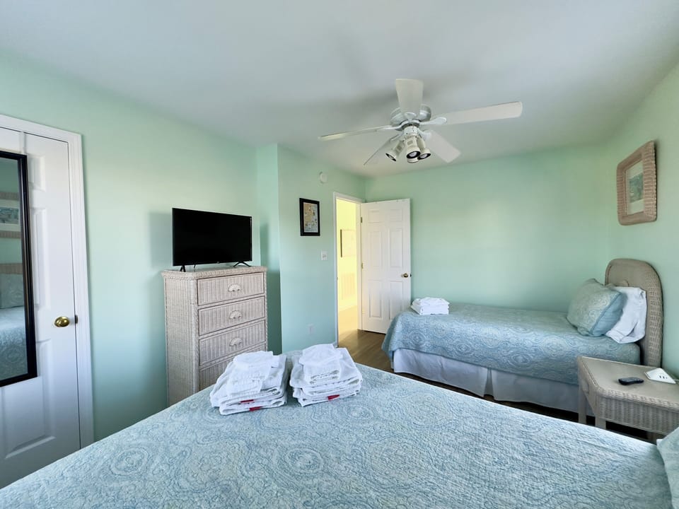 2nd floor bedroom with twin bed, queen bed, and smart TV.