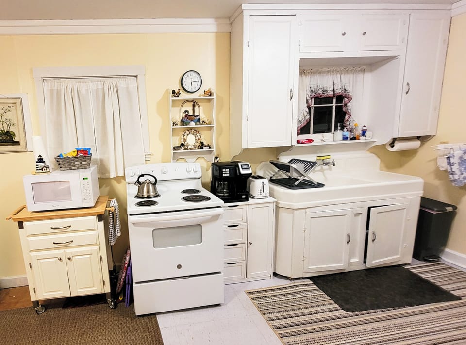 Kitchen Full-size refrigerator, stove & microwave; silverware, plates & utensils