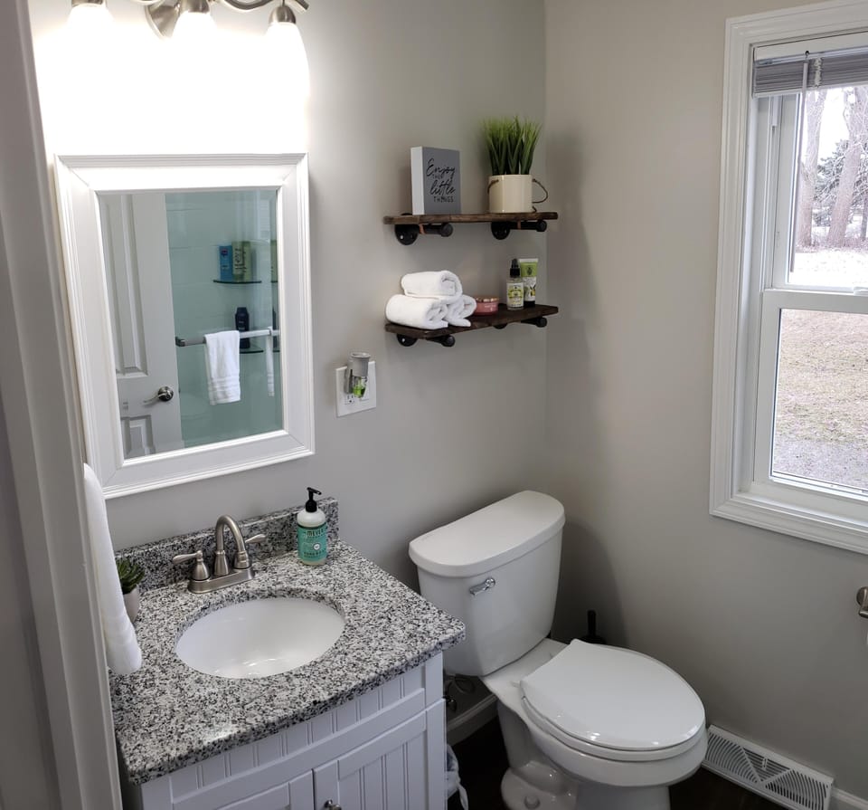 Our updated bathroom features a granite countertop and plenty of lighting.