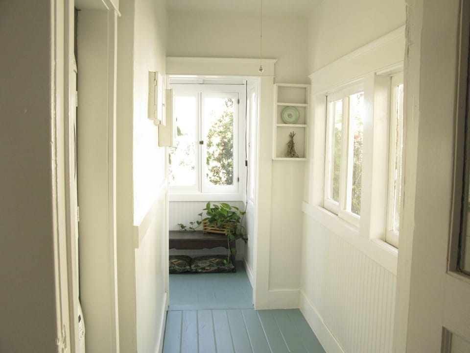 Hallway from the kitchen to the porch is cute, with a painted wood floor