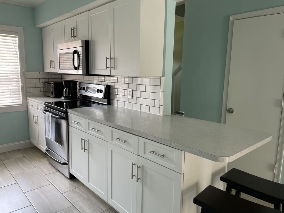 Large counter top with two counter stools ideal for additional seating