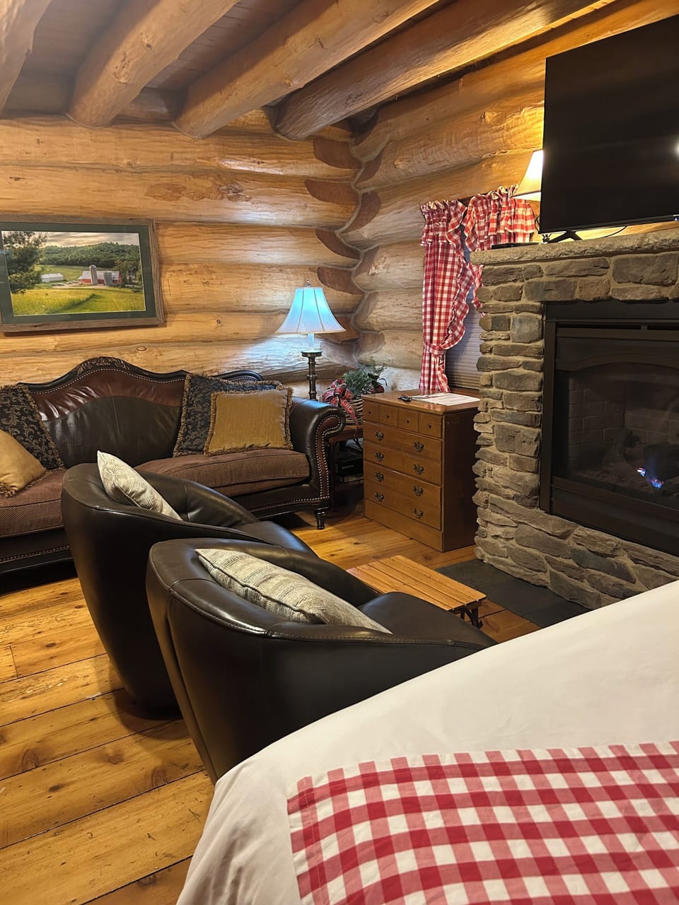 Queen bed, leather barrel chairs and leather couch with gas fireplace
