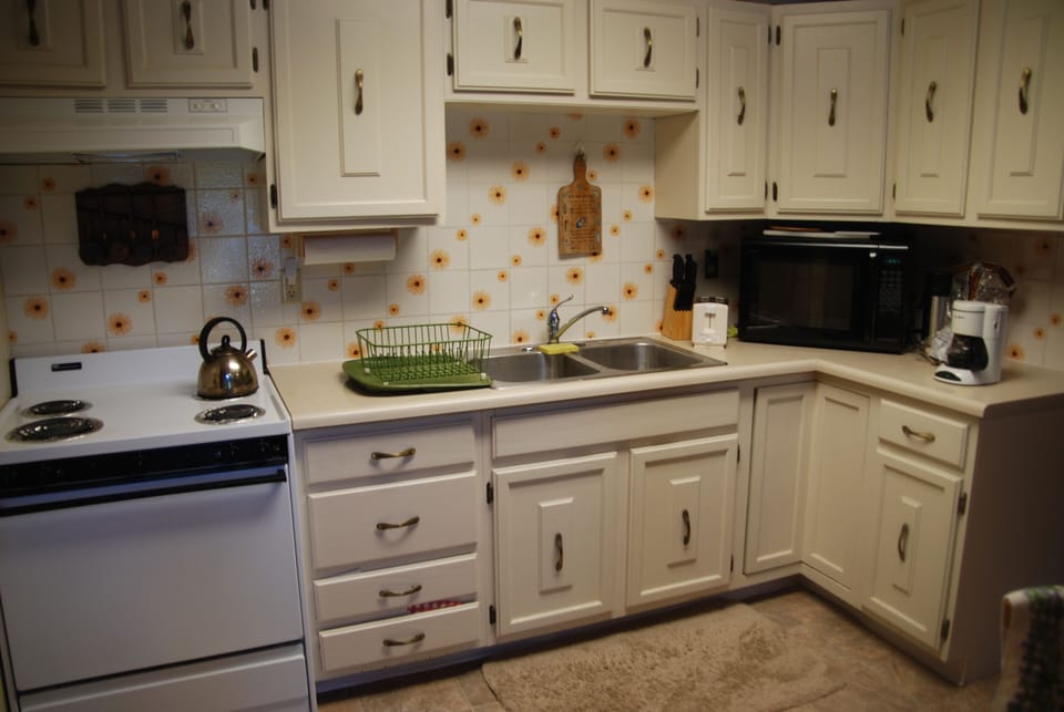 Kitchen has range, microwave, refrigerator, coffee maker, blender, cookware