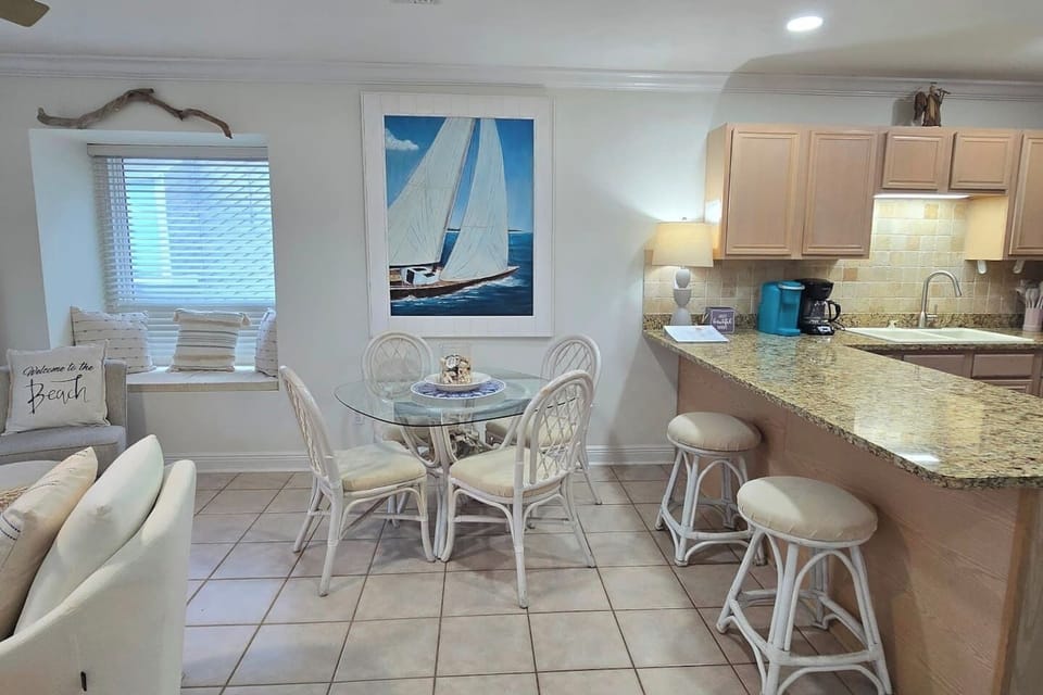 Seat everyone at once — dining table for four plus two more at the breakfast bar means nobody eats standing up on vacation.