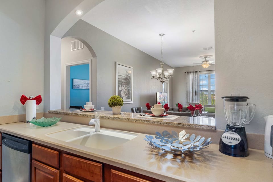 Open-concept living from the kitchen-chat at the granite breakfast bar while dinner simmers, with the bright dining area and cozy lounge just beyond.