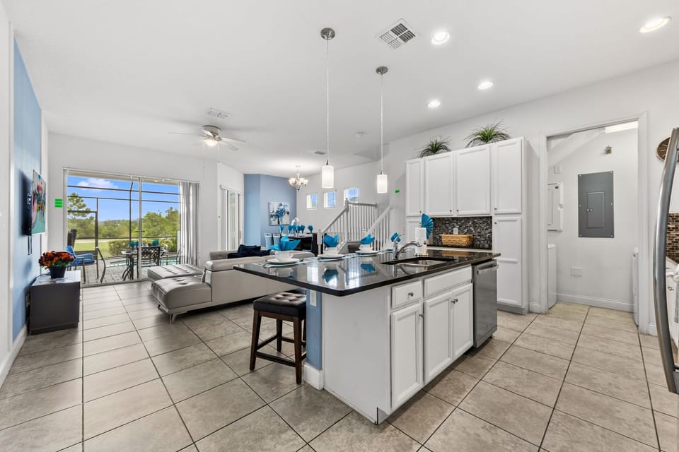 Gather in the airy open-concept kitchen with granite island seating, stainless appliances, and a sunny view to the patio-great for shared meals and easy entertaining!