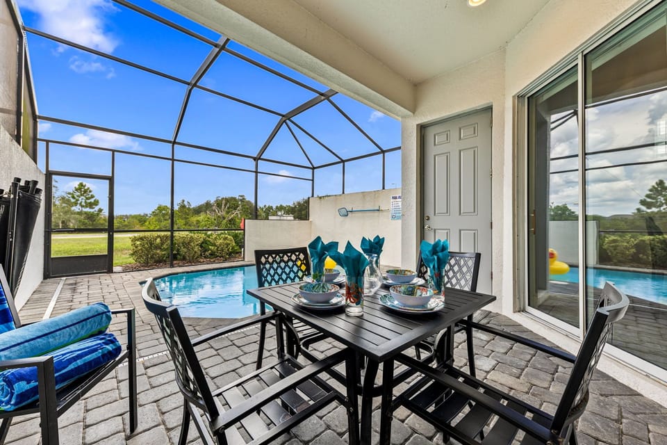 Dine poolside on the screened patio with a resort-style vibe, comfy seating, and a sparkling private pool just steps away-ideal for laid-back outdoor meals!