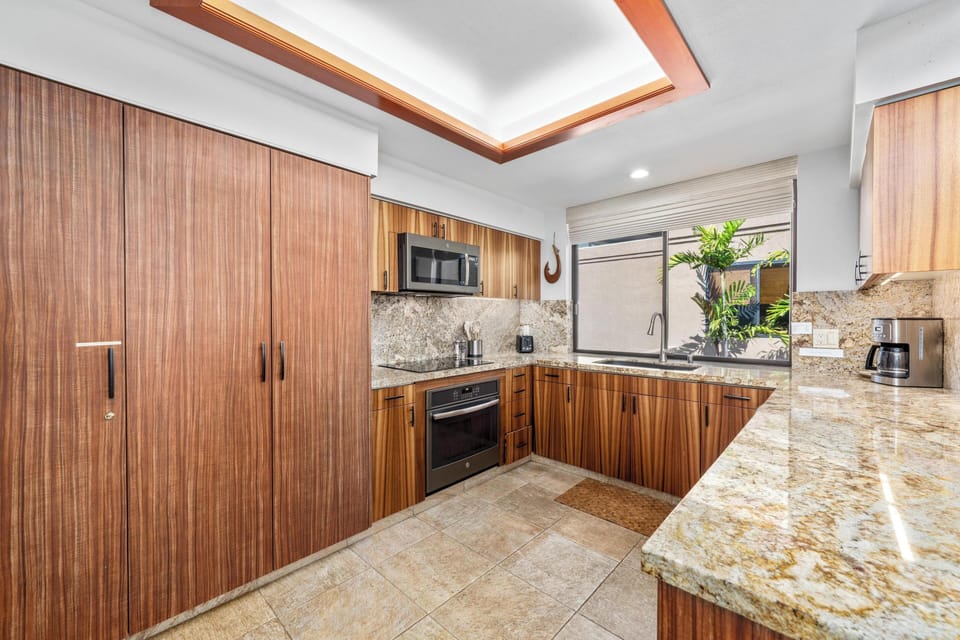Your gourmet kitchen features warm wood cabinets, granite countertops, and modern appliances, perfectly designed for preparing memorable meals during your stay.