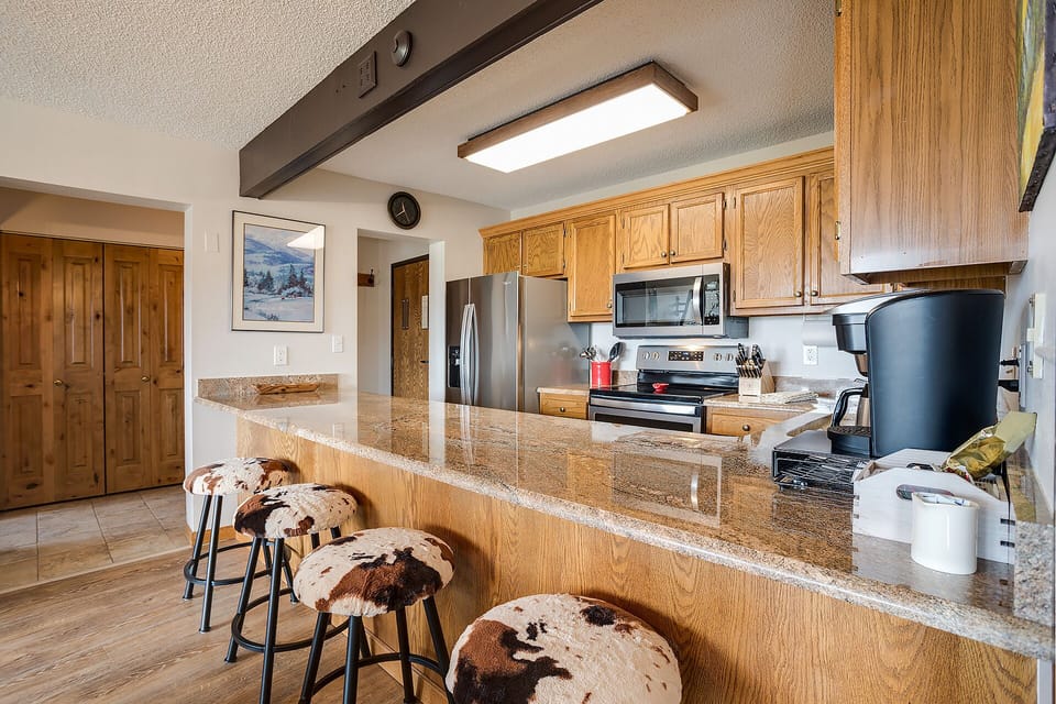 Your spacious kitchen features granite countertops, full-size appliances, and rustic cowhide bar stools for casual dining and morning coffee.