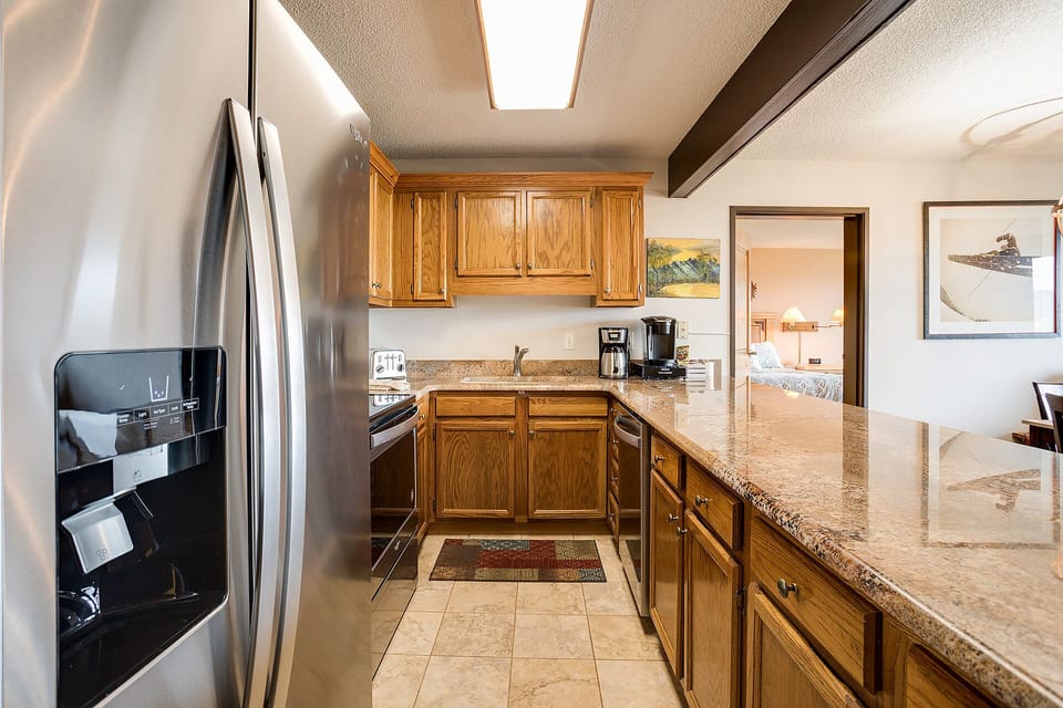 Your fully-equipped kitchen awaits with granite counters, stainless steel appliances, and rich wood cabinetry for memorable home-cooked meals.