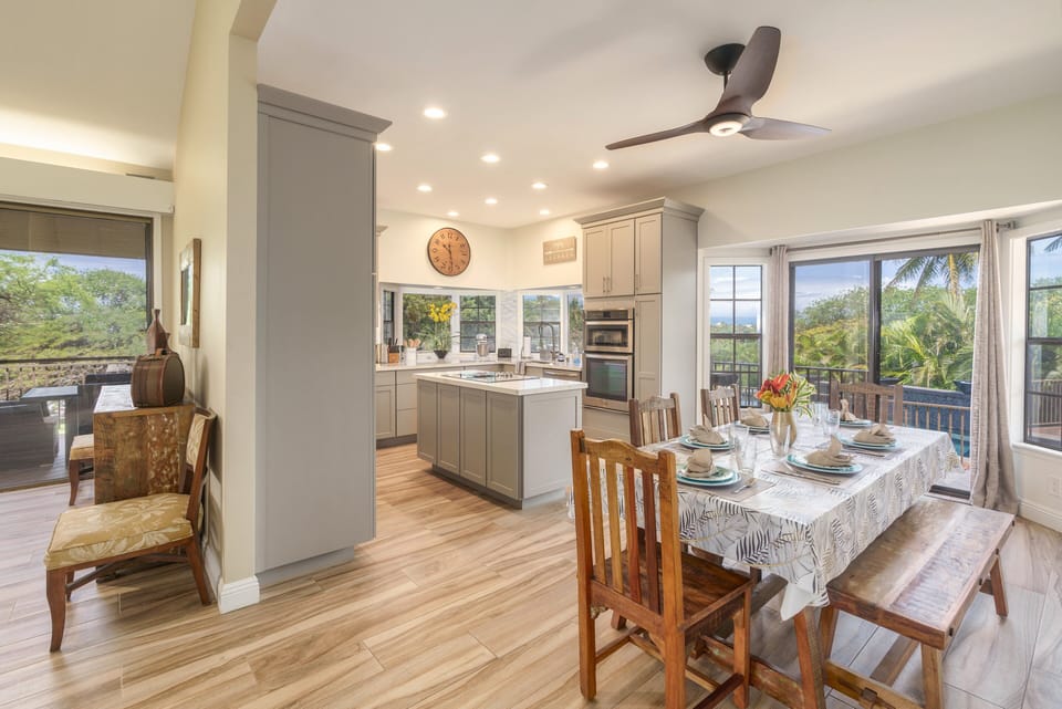 A cozy dining area located next to large windows with pool views, perfect for enjoying meals with a beautiful outdoor backdrop in Lahaina.