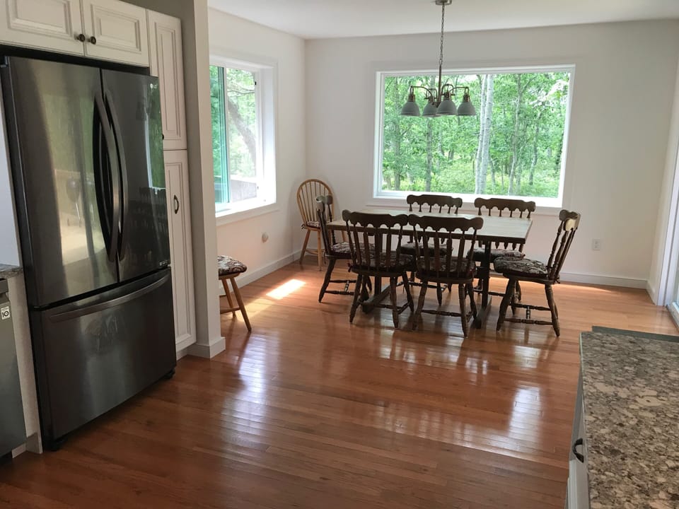 View of dining room from kitchen. Bright with a south view of wooded area.