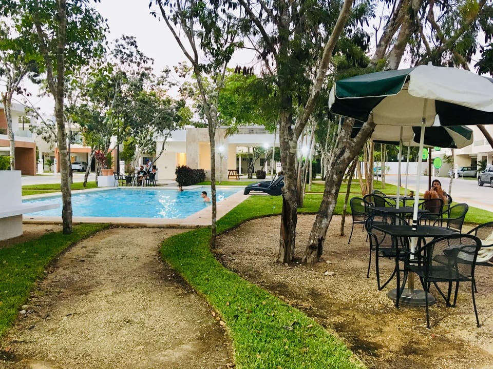 Common area with tables to relax, BBQ to grill and the pool.