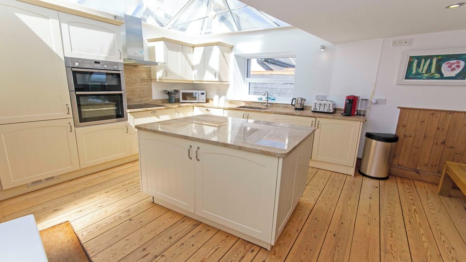 Kitchen cooking with a glass vaulted ceiling star gazing from indoors