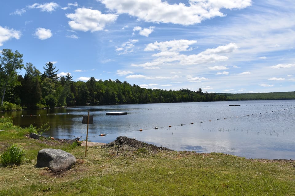 Public beach with two floating docks and boat launch. 