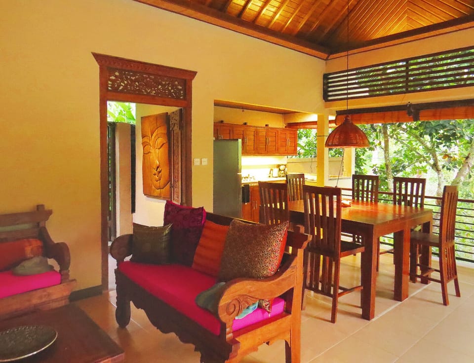 View of the dining area and kitchen in background, seating area in foreground.