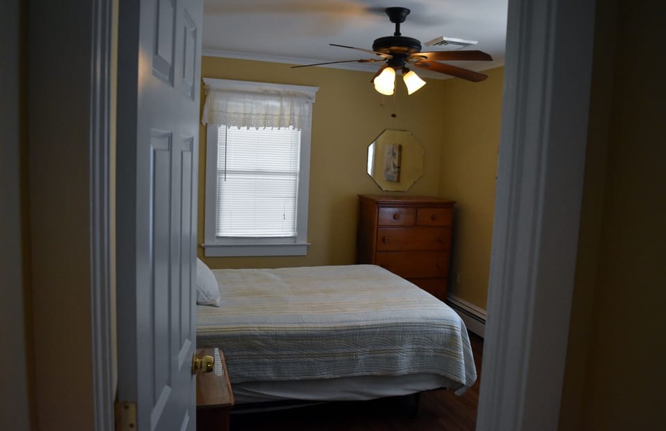bedroom with closet, and queen sized bed. dresser, night stand, and chair
