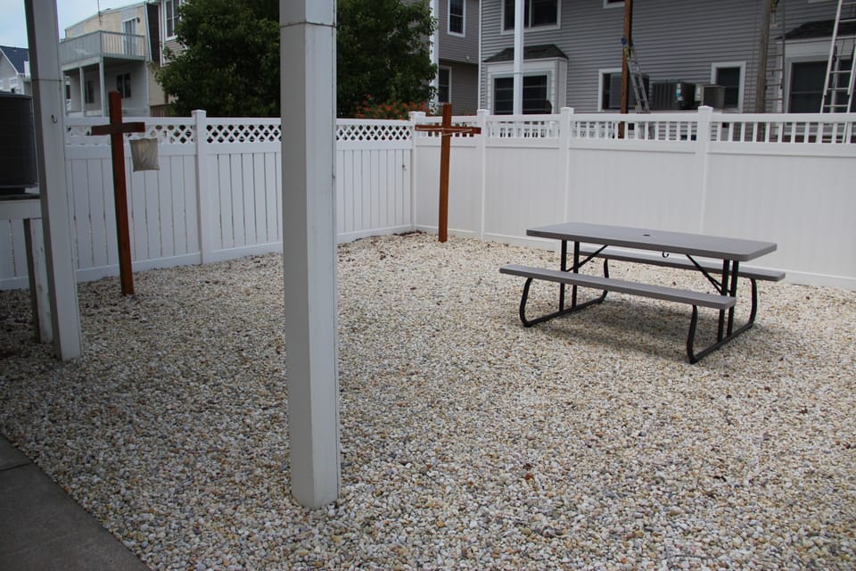 Fully fenced back yard with picnic table, outdoor shower and large clothes line.
