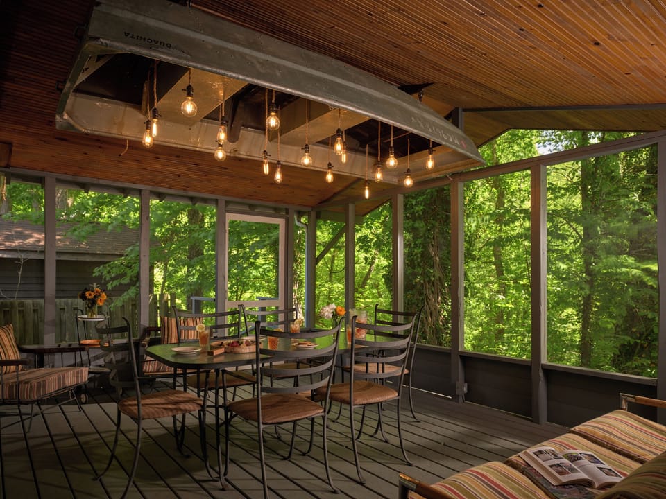 Large screen porch with river views and custom rowboat light fixture.