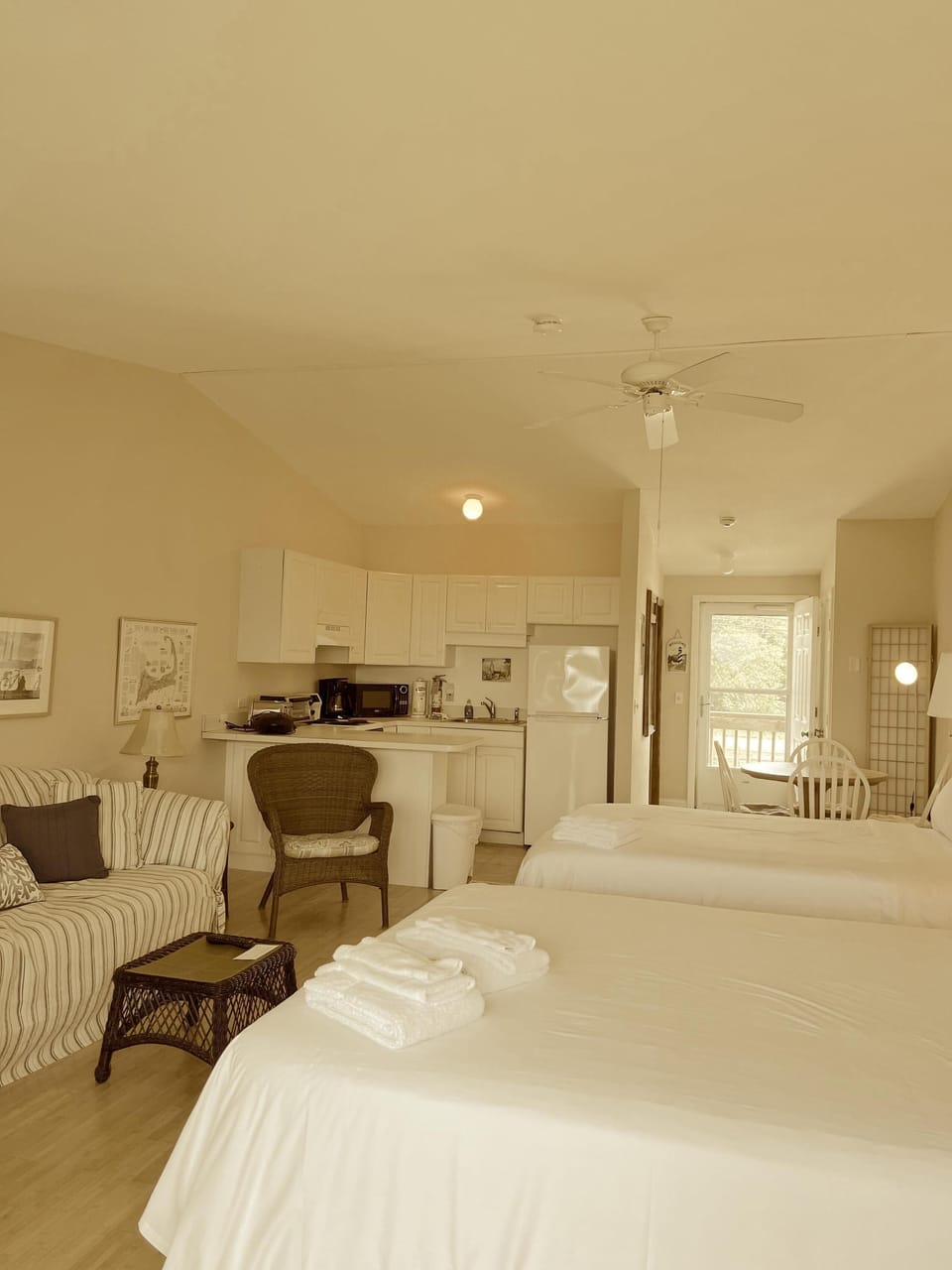 Bright and airy bedroom with cozy seating and open kitchen view