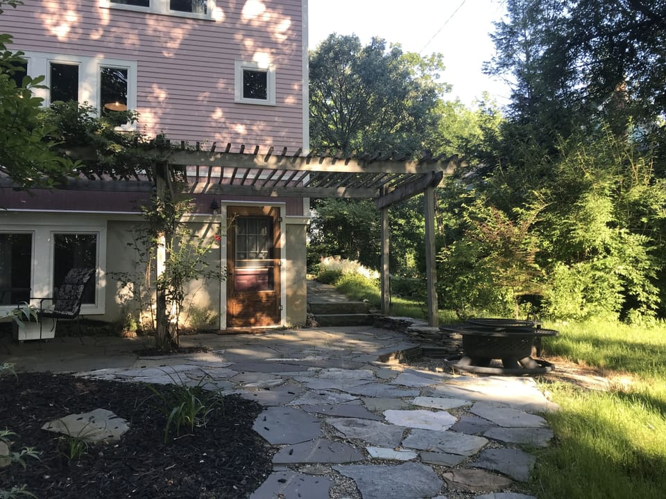 Patio, fire pit, and back entrance under arbor