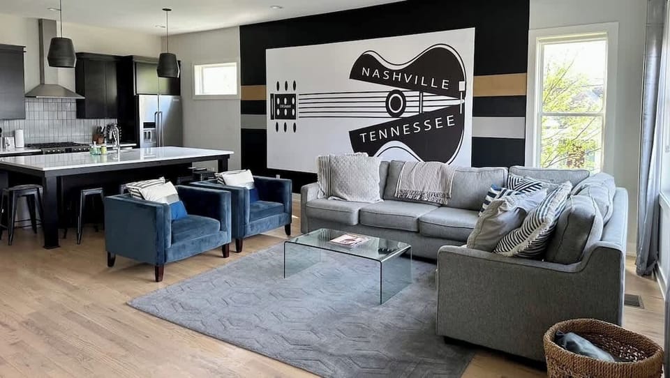 Unit 1 - Light Filled Living Room with amazing artwork, over-sized custom made sectional sofa, and plush arm chairs. Enjoy a movie on 65" SmartTV