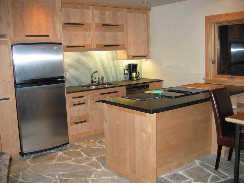 Modern kitchen well stocked with gourmet cookware and untensils.