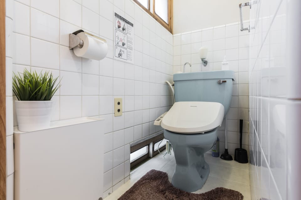 idy toilet space featuring bidet, houseplant and usage guide