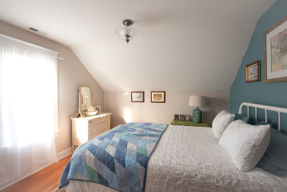 Guest room with queen size bed,  comforter and pillows.