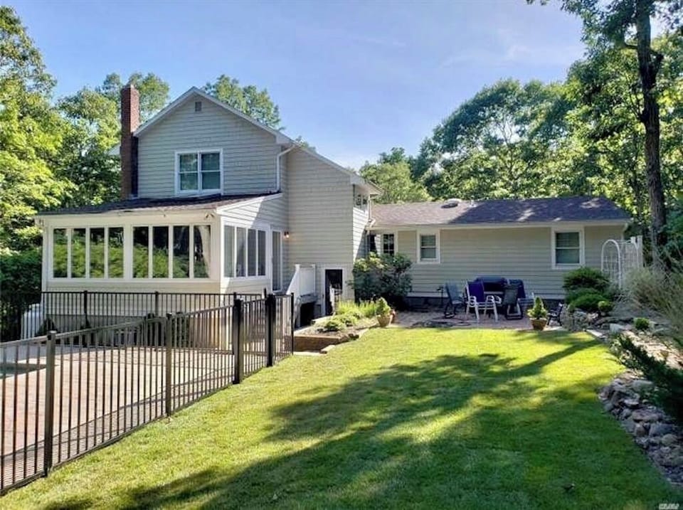 Flat back yard and patio with gas grill.