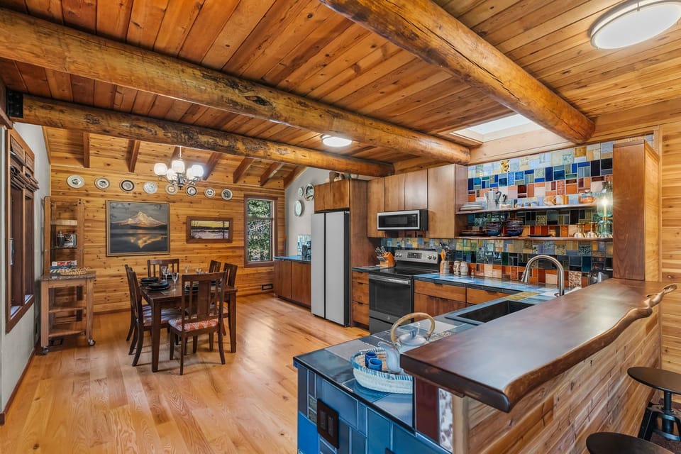 Gather around the beautiful live-edge kitchen island, where rich wood beams and vibrant tile work create a welcoming space for your culinary adventures and cozy cabin meals.
