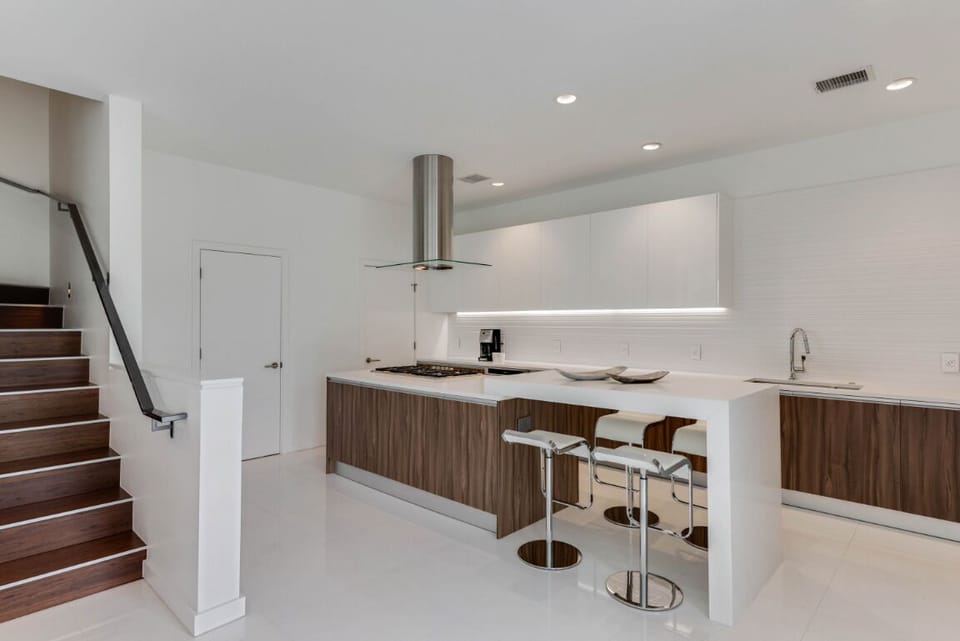 Kitchen has an island eating area.  Doors are to a pantry and powder room.