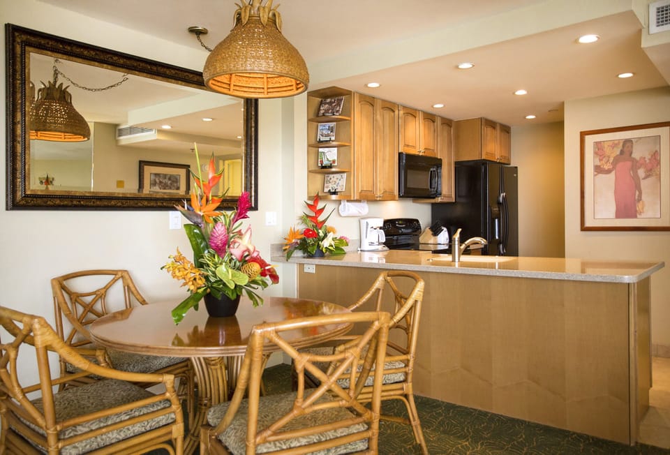 Your open dining and kitchen area features a full breakfast bar, modern appliances, and tropical décor that brings warm island vibes into every meal.