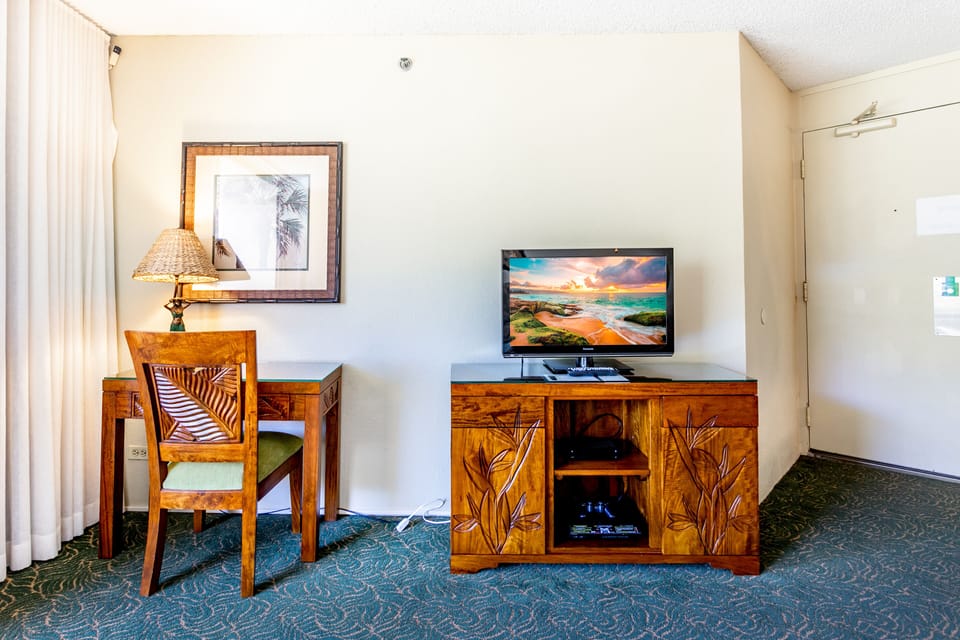 Unwind in your cozy retreat with charming tropical-inspired décor, a comfortable workspace, and entertainment ready for your evening relaxation.