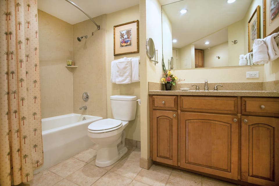 Bright, spacious bathroom with warm tones and thoughtful details to make your stay feel like home. Fresh towels, granite counters, and a relaxing tub await you after a day exploring.